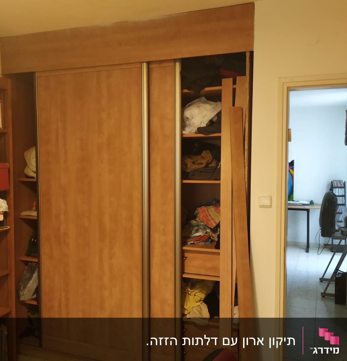 ארון עץ עם דלתות הזזה פתוחות וחלקי עץ בצד